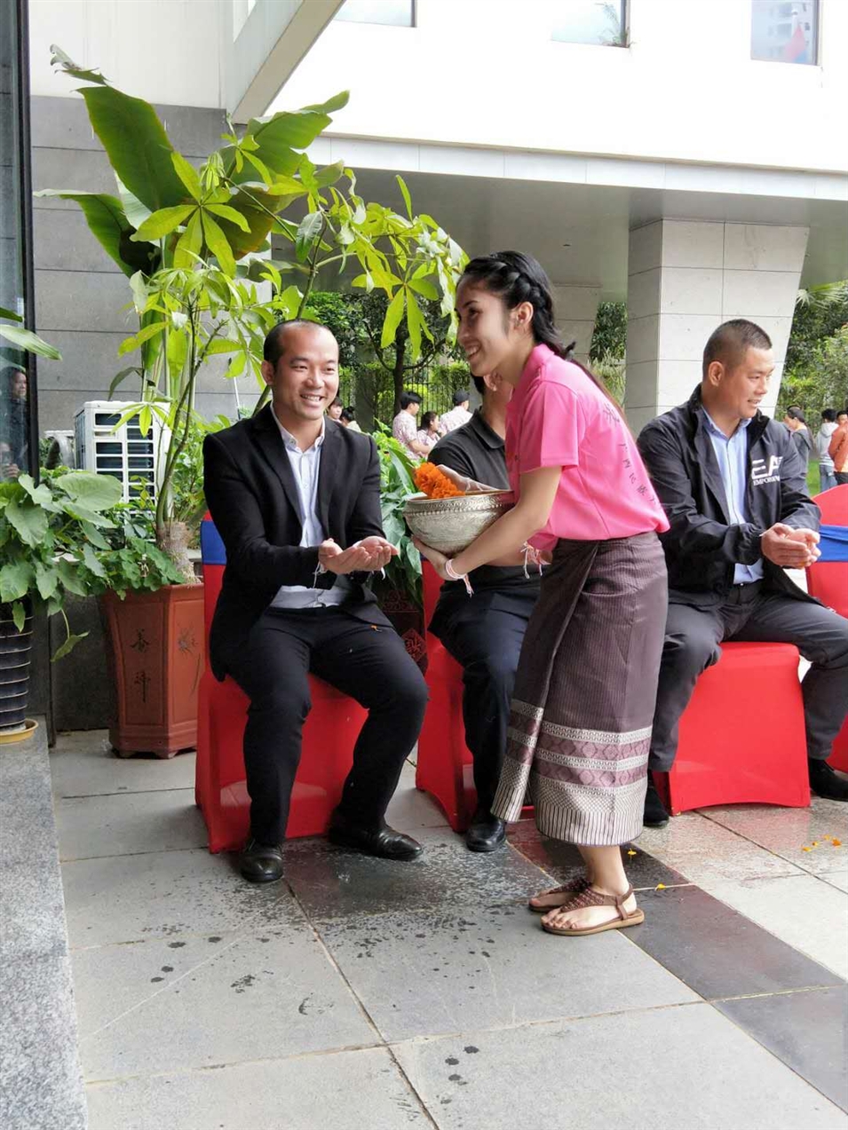 老撾駐廣西留學(xué)生代表將浸有花瓣的香水灑客人的手上，表示對(duì)嘉賓的美好祝福（圖一）