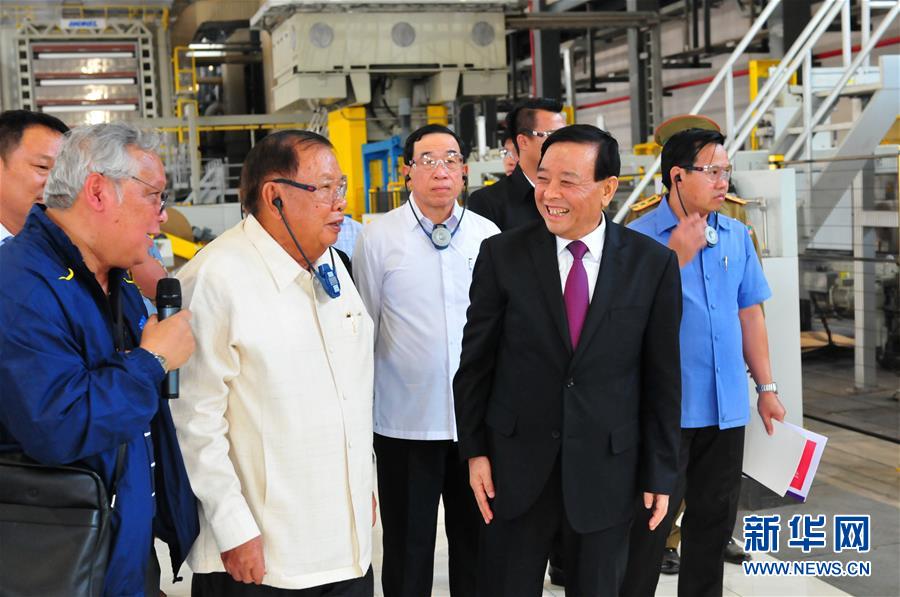 3月10日，在老撾沙灣拿吉省車邦縣，老撾人民革命黨中央總書記、國家主席本揚（左二）在山東太陽紙業(yè)股份有限公司董事長李洪信（右二）的陪同下視察公司。 新華社記者章建華攝